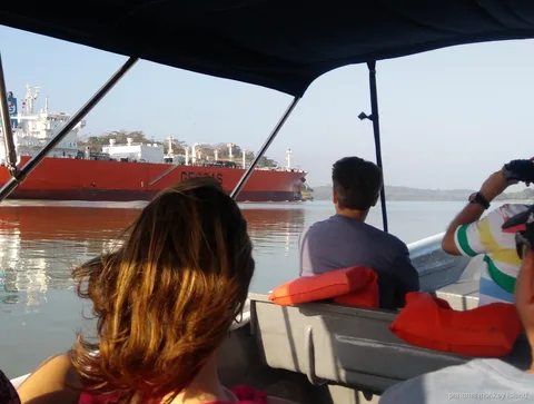 Vista desde un bote con toldo de un buque cisterna rojo en el Canal de Panamá, crucero isla de los monos Panamá