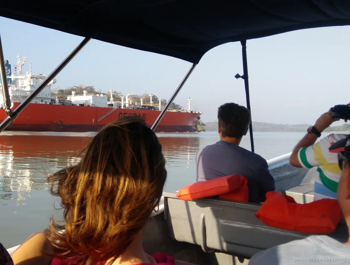 Vista desde un bote con toldo de un buque cisterna rojo en el Canal de Panamá, crucero isla de los monos Panamá