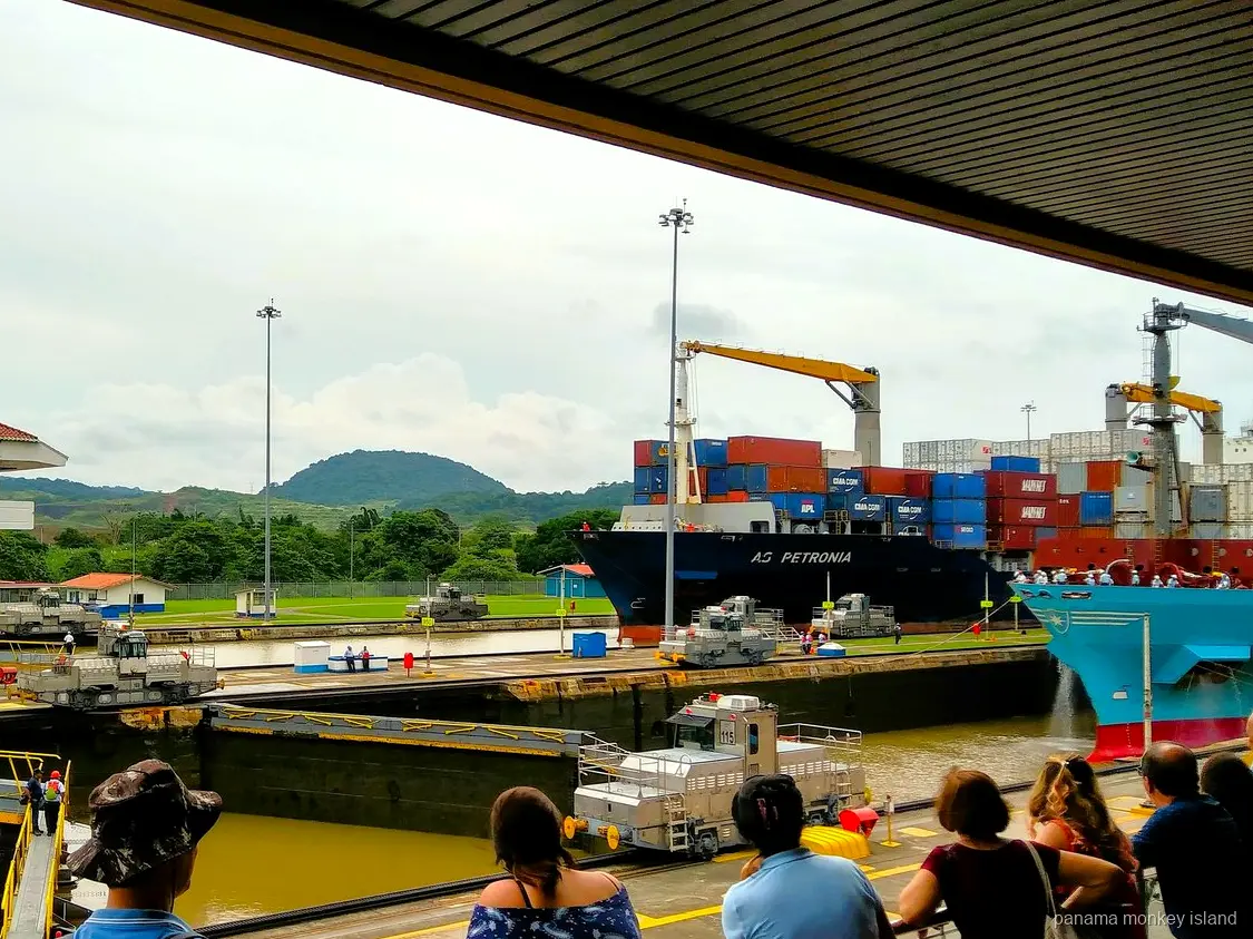 Container ship in the Miraflores Locks watched by visitors, part of a panama monkey island combo tour